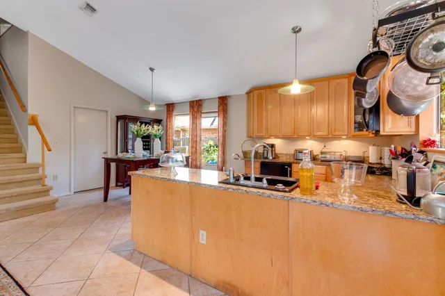 a kitchen with stainless steel appliances granite countertop a sink a stove and a wooden floors
