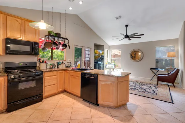 a kitchen with stainless steel appliances granite countertop a stove refrigerator and a sink