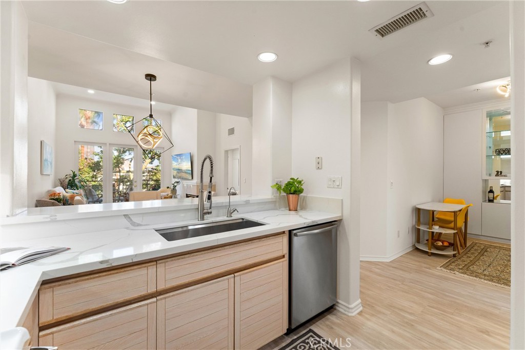 2243 Martin, Unit 415 Irvine, CA 92612 - Photo 23 of 34 a kitchen with stainless steel appliances kitchen island granite countertop a sink and wooden cabinets