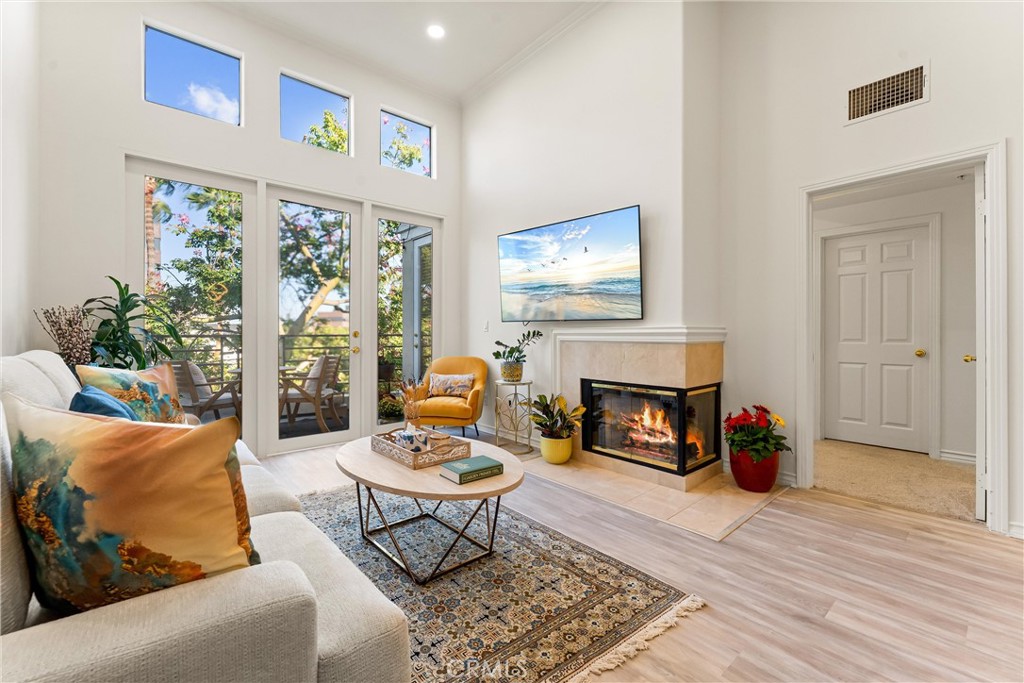 2243 Martin, Unit 415 Irvine, CA 92612 - Photo 3 of 34 a living room with furniture a fireplace and a flat screen tv
