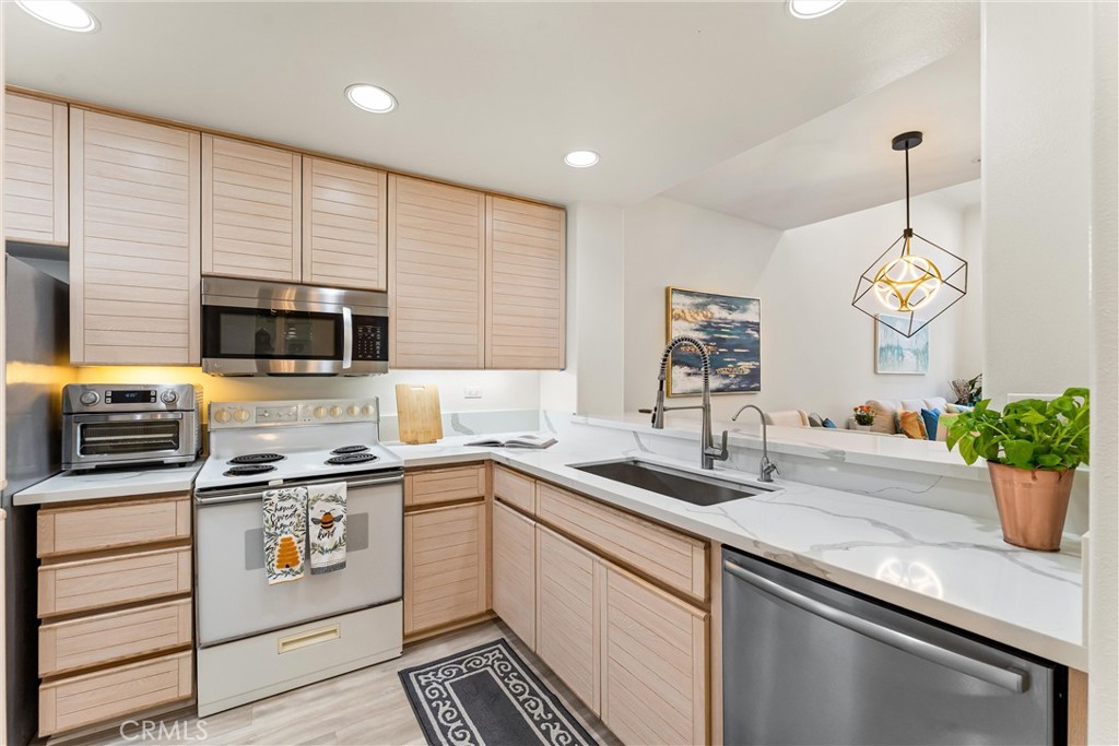 2243 Martin, Unit 415 Irvine, CA 92612 - Photo 9 of 34 a kitchen with stainless steel appliances a sink a stove and cabinets