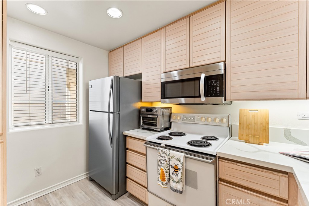2243 Martin, Unit 415 Irvine, CA 92612 - Photo 10 of 34 a kitchen with stainless steel appliances a refrigerator a stove a microwave and cabinets