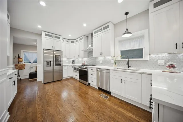 a kitchen with white cabinets appliances and a sink
