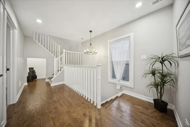 a view of hallway with wooden floor and stairs