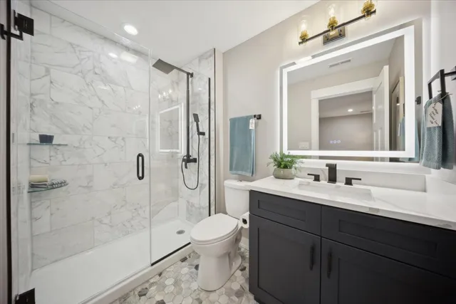 a bathroom with a sink a toilet and shower