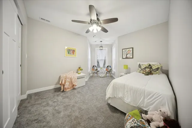 a spacious bedroom with a bed and a chandelier