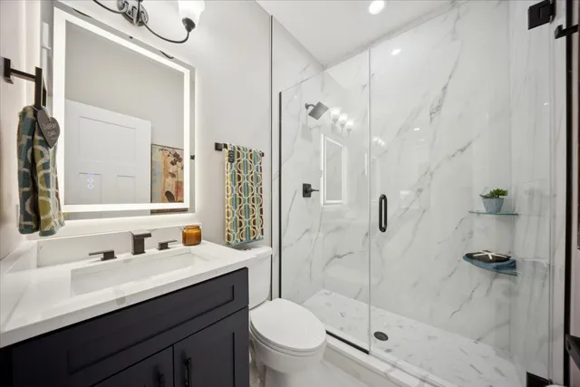 a bathroom with a sink a toilet and shower