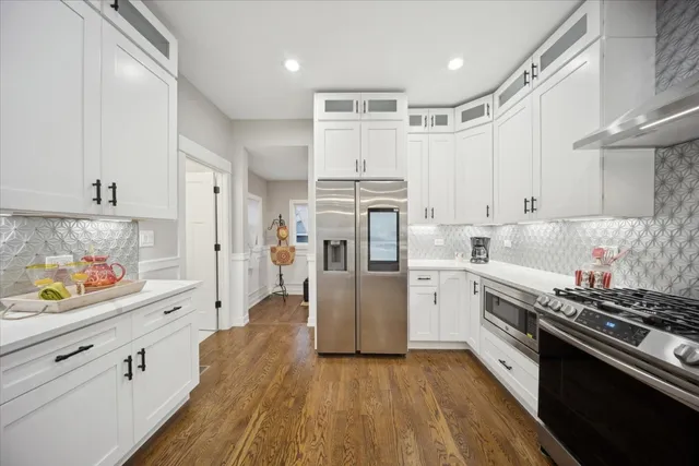 a kitchen with white cabinets and stainless steel appliances