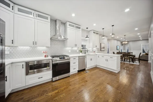 a kitchen with stainless steel appliances granite countertop a stove and white cabinets