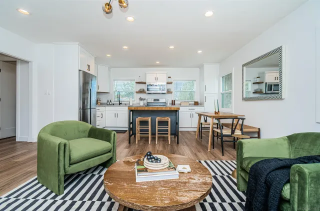 a living room with furniture and a dining table with kitchen view