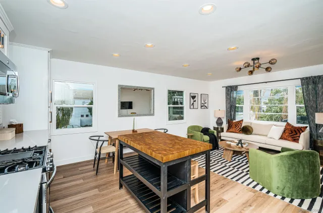 a living room with furniture a table and wooden floor