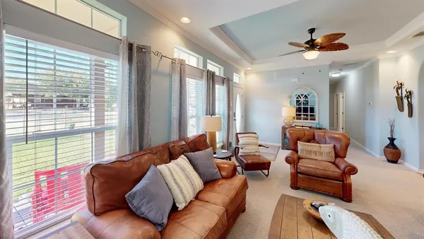 a living room with furniture a flat screen tv and a floor to ceiling window