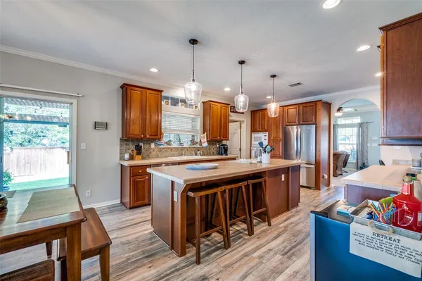 a kitchen with stainless steel appliances granite countertop a sink a refrigerator and a stove