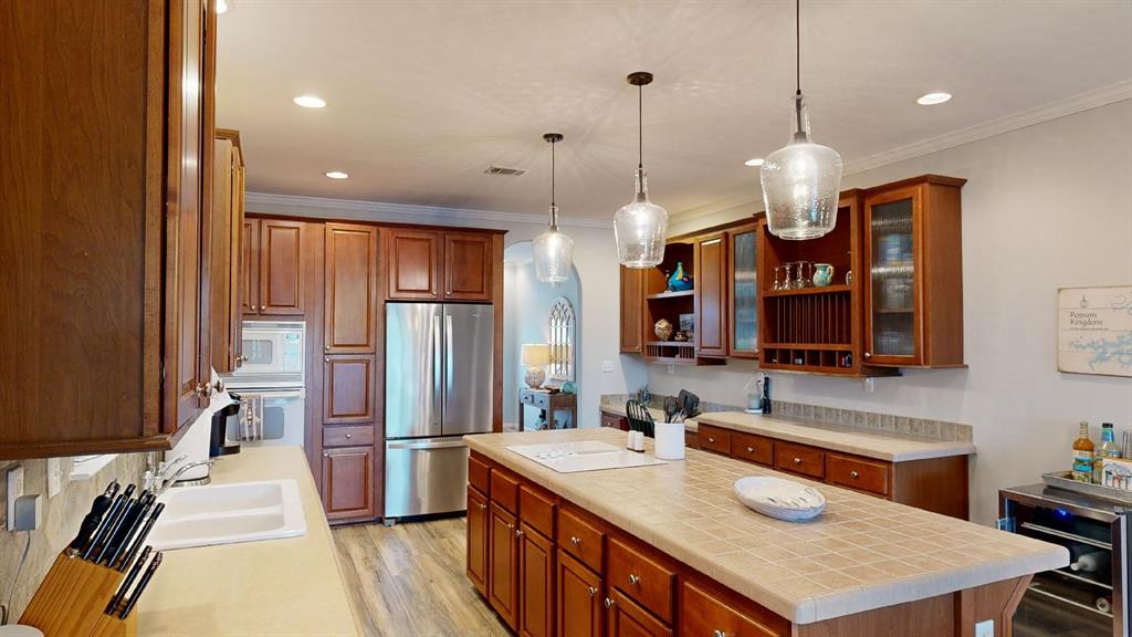 4925 Butler Lane Graham, TX 76450 - Photo 18 of 36 a kitchen with stainless steel appliances granite countertop a sink a refrigerator and a stove