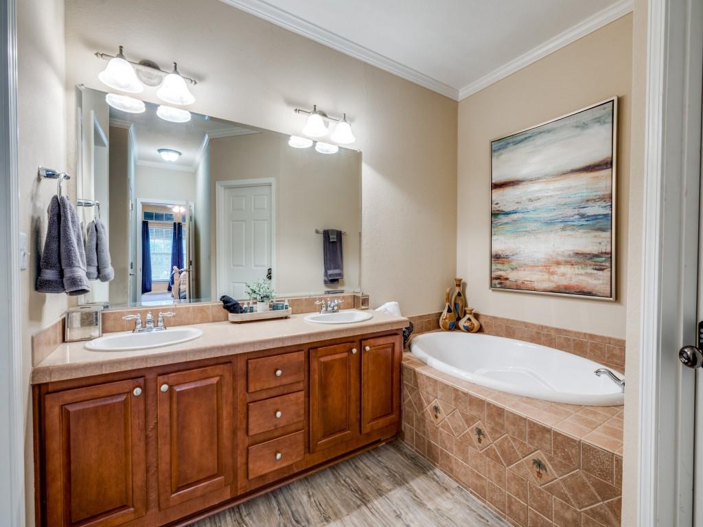 4925 Butler Lane Graham, TX 76450 - Photo 21 of 36 a bathroom with a double vanity sink a large mirror and a bathtub
