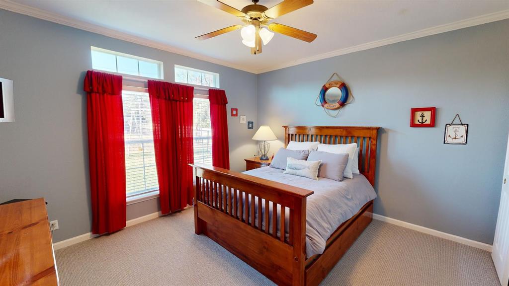 4925 Butler Lane Graham, TX 76450 - Photo 24 of 36 a bedroom with a bed and a chandelier