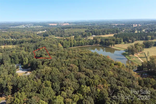 an aerial view of residential houses with outdoor space and trees