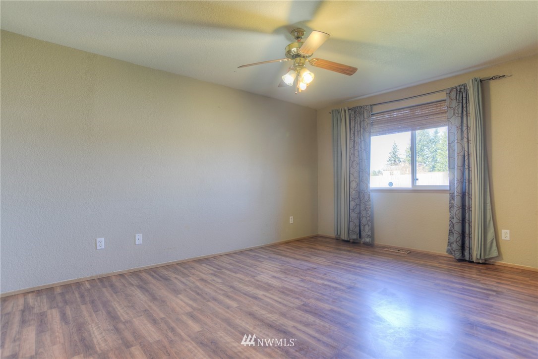 9320 181st Way Southwest Rochester, WA 98579 - Photo 12 of 21 an empty room with wooden floor and windows