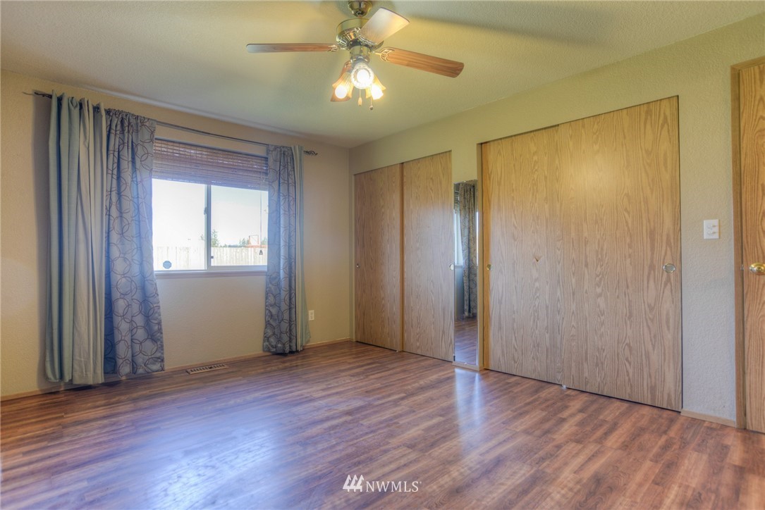9320 181st Way Southwest Rochester, WA 98579 - Photo 13 of 21 an empty room with wooden floor and a ceiling fan