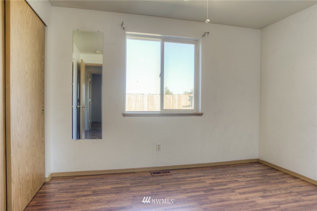 9320 181st Way Southwest Rochester, WA 98579 - Photo 17 of 21 an empty room with wooden floor and windows