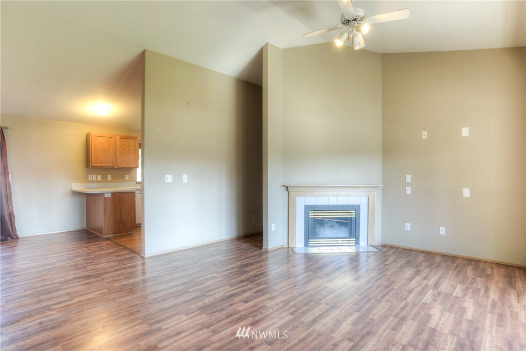 9320 181st Way Southwest Rochester, WA 98579 - Photo 4 of 21 a view of empty room with wooden floor and fireplace