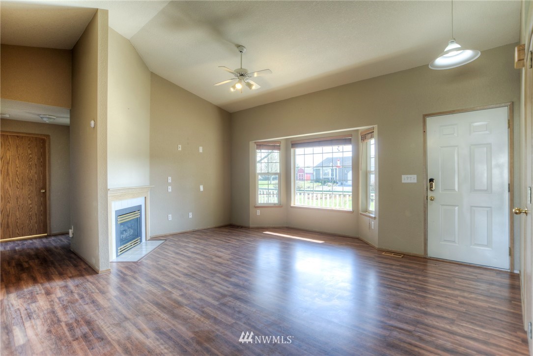 9320 181st Way Southwest Rochester, WA 98579 - Photo 5 of 21 a view of an empty room with wooden floor and a window