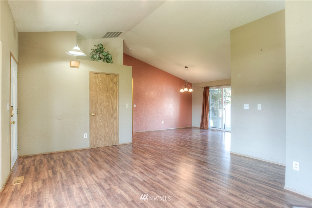 9320 181st Way Southwest Rochester, WA 98579 - Photo 7 of 21 a view of an empty room and window and wooden floor