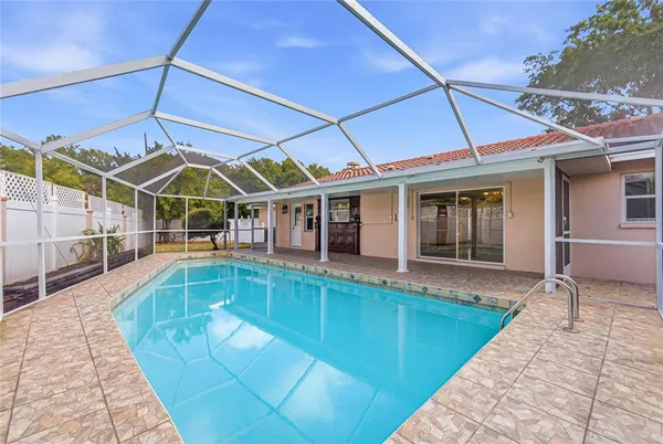 a view of a white building with swimming pool in front of it