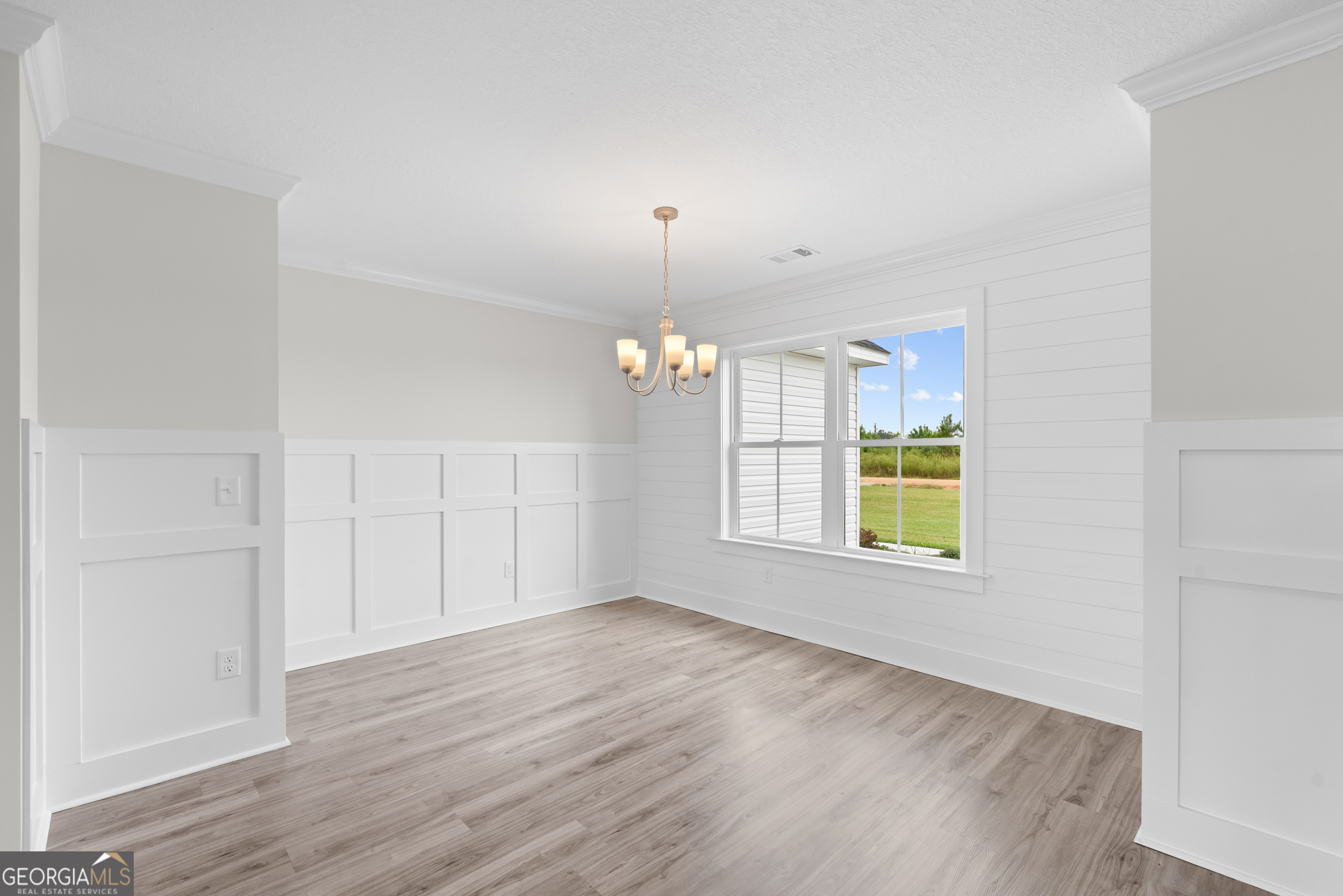 543 Jack Kennedy Road Statesboro, GA 30458 - Photo 11 of 35 an empty room with wooden floor and windows