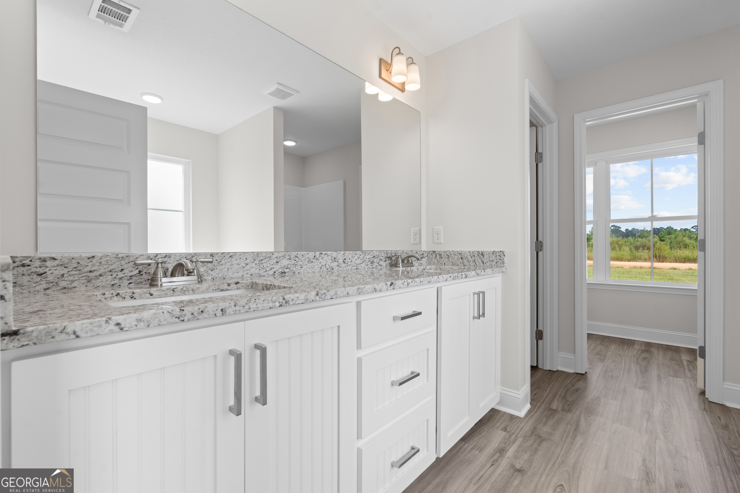 543 Jack Kennedy Road Statesboro, GA 30458 - Photo 14 of 35 a bathroom with a granite countertop sink and a mirror