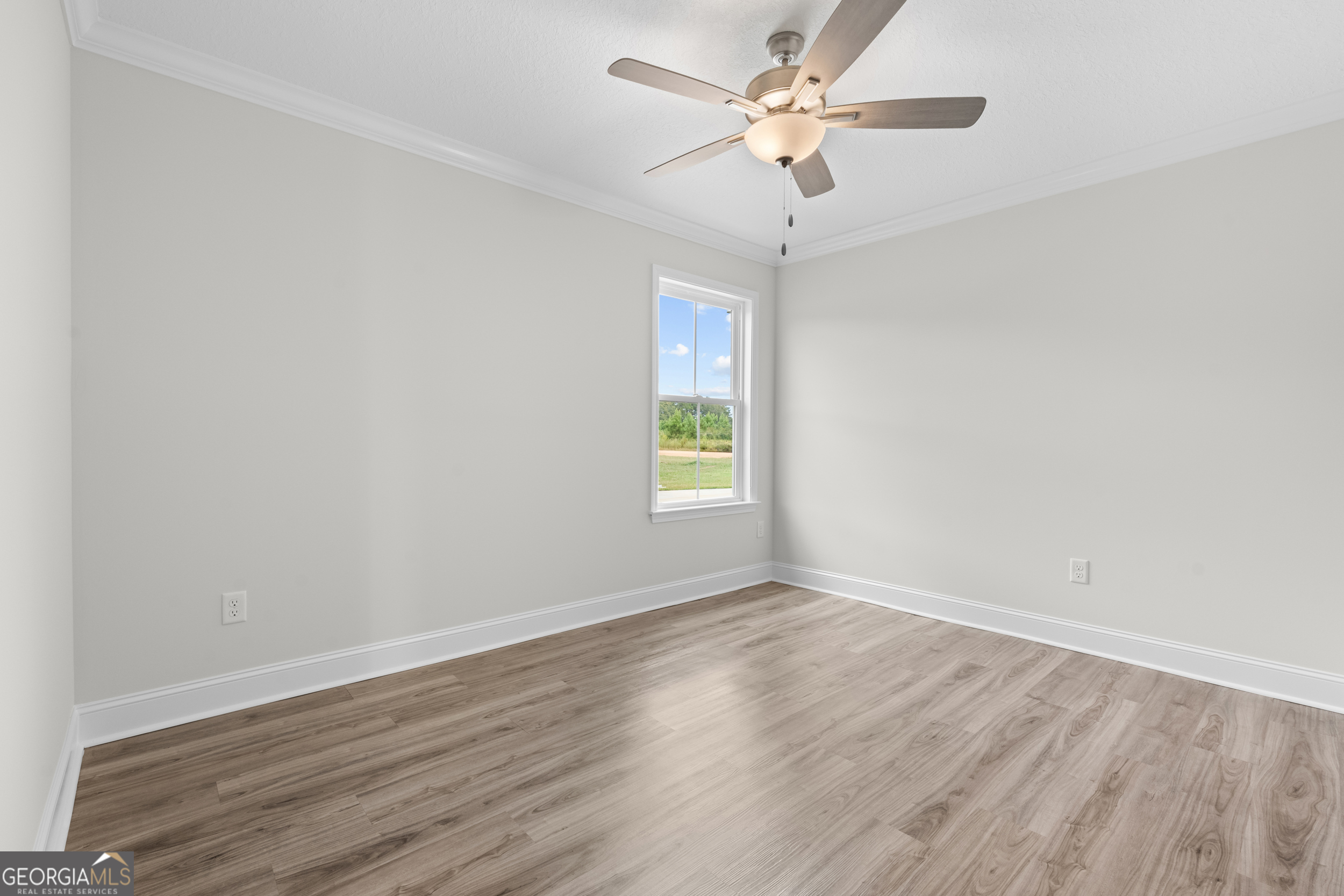 543 Jack Kennedy Road Statesboro, GA 30458 - Photo 18 of 35 an empty room with wooden floor ceiling fan and window