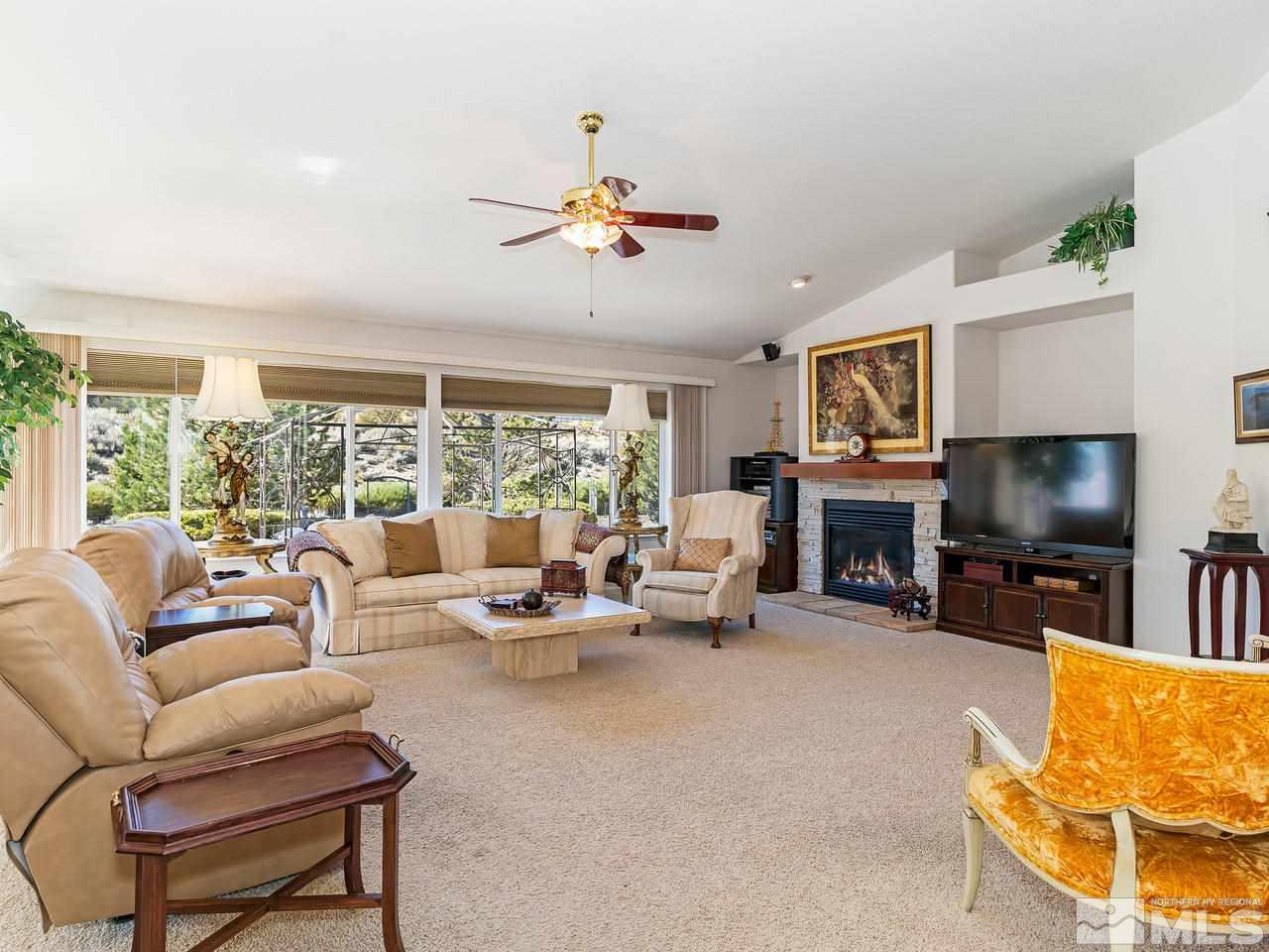 15523 Quicksilver Drive Reno, NV 89511 - Photo 3 of 25 a living room with furniture a fireplace and a flat screen tv