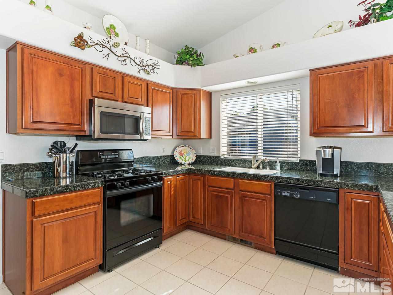 15523 Quicksilver Drive Reno, NV 89511 - Photo 9 of 25 a kitchen with stainless steel appliances granite countertop a stove sink microwave and window