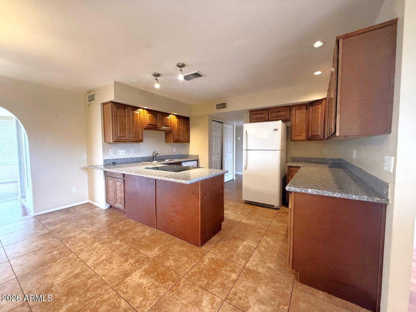 4625 South Rita Lane Tempe, AZ 85282 - Photo 4 of 16 a kitchen with a refrigerator and a stove top oven