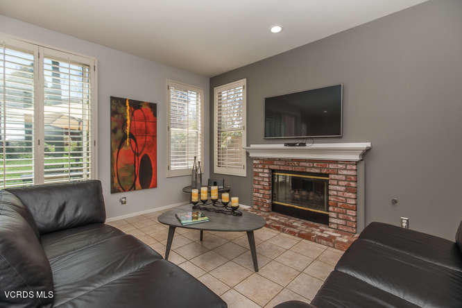 11218 Shadyridge Road Moorpark, CA 93021 - Photo 19 of 48 a living room with furniture a flat screen tv and a fireplace