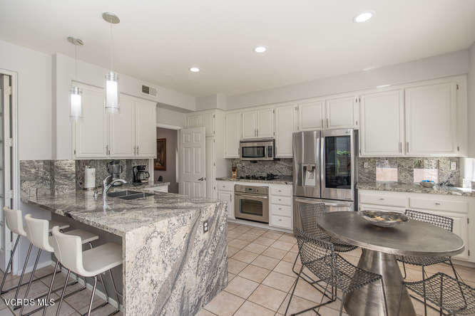 11218 Shadyridge Road Moorpark, CA 93021 - Photo 25 of 48 a kitchen with stainless steel appliances kitchen island granite countertop a sink refrigerator and cabinets