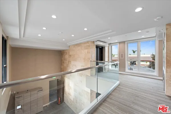 a view of a hallway with wooden floor and chandelier