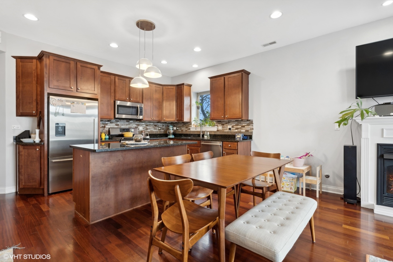 2841 North Pulaski Road, Unit 2S Chicago, IL 60641 - Photo 6 of 15 a kitchen with stainless steel appliances granite countertop a stove top oven a refrigerator a sink and a dining table with wooden floor