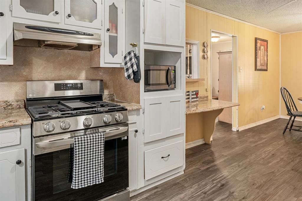 508 West 9th Street Kemp, TX 75143 - Photo 11 of 32 a kitchen with stainless steel appliances a stove a microwave and cabinets