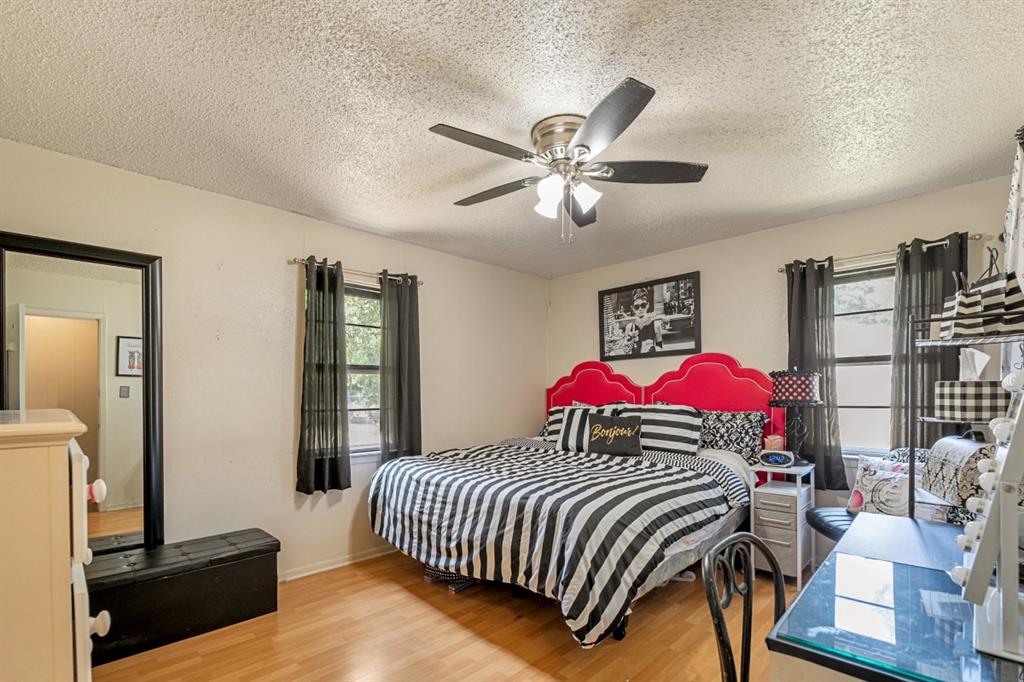 508 West 9th Street Kemp, TX 75143 - Photo 15 of 32 a bedroom with a bed and a chandelier