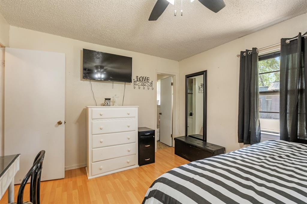 508 West 9th Street Kemp, TX 75143 - Photo 16 of 32 a bedroom with a bed and a flat screen tv
