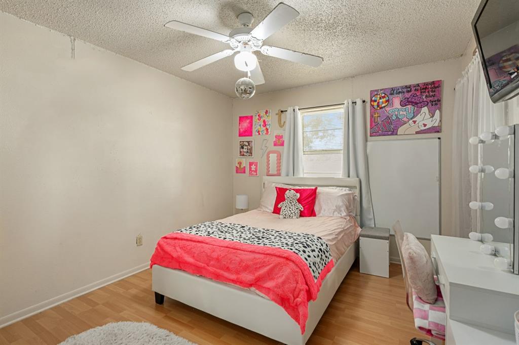 508 West 9th Street Kemp, TX 75143 - Photo 18 of 32 a bedroom with a bed and a chandelier