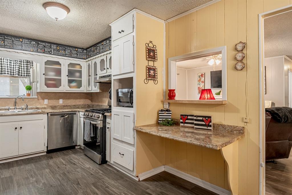 508 West 9th Street Kemp, TX 75143 - Photo 10 of 32 a kitchen with stainless steel appliances granite countertop a stove and a refrigerator
