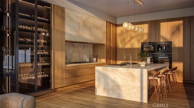 a living room with stainless steel appliances furniture a large window and a kitchen view