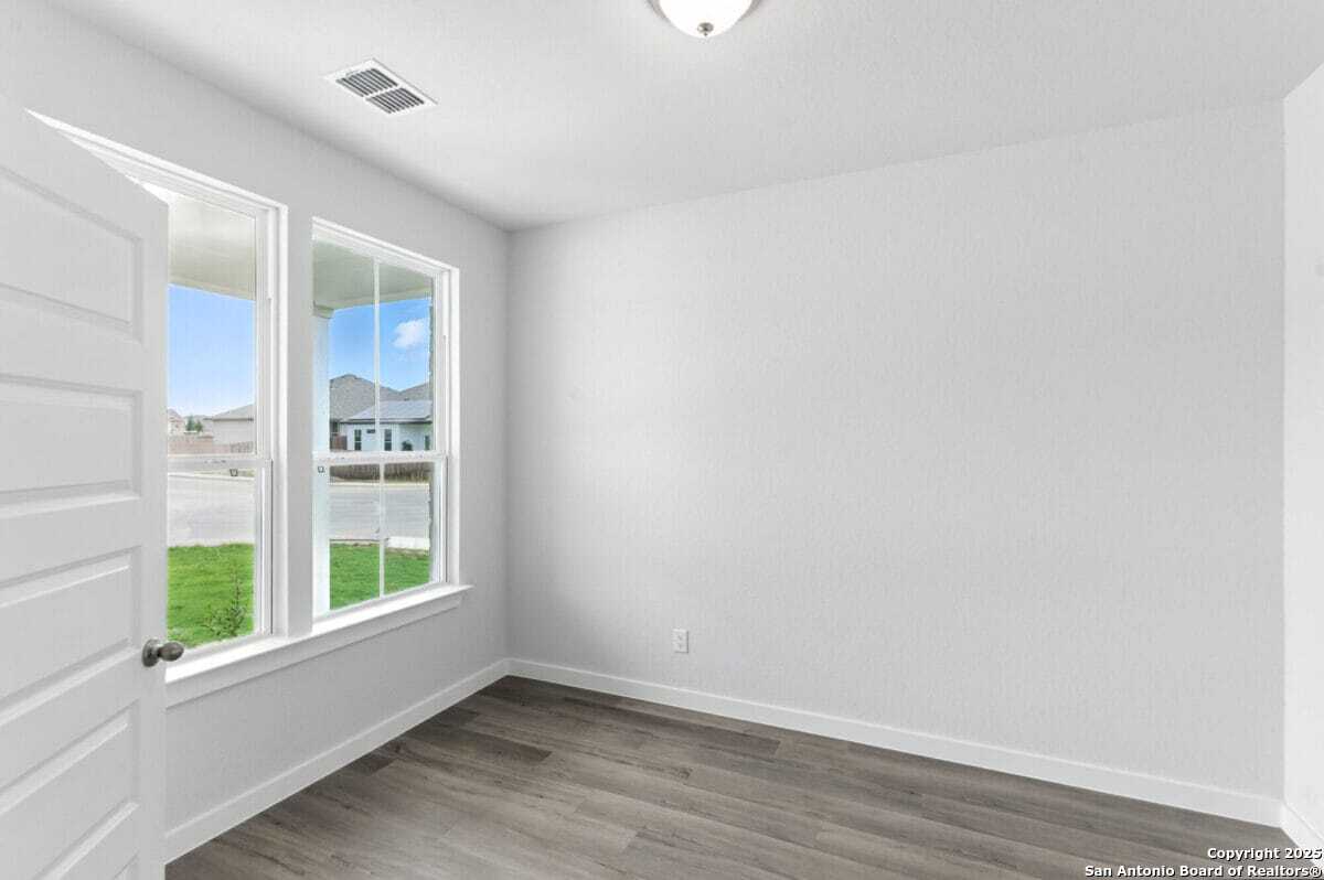 1896 Split Rock Road New Braunfels, TX 78130 - Photo 21 of 22 a view of an empty room with wooden floor and a window