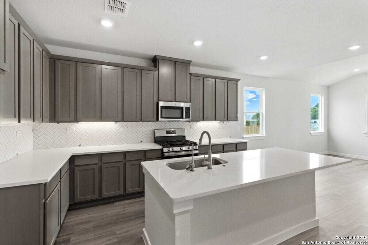 1896 Split Rock Road New Braunfels, TX 78130 - Photo 5 of 22 a kitchen with a sink white cabinets and stainless steel appliances