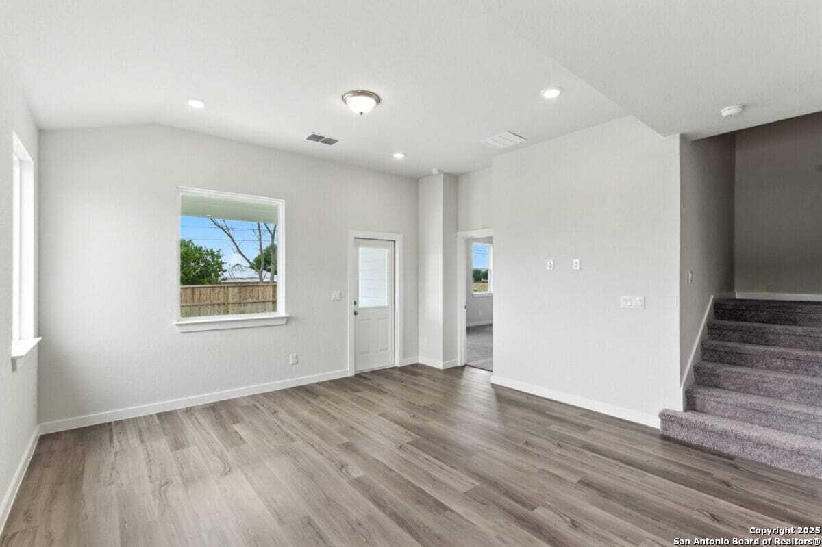 1896 Split Rock Road New Braunfels, TX 78130 - Photo 8 of 22 a view of an empty room with wooden floor and a window