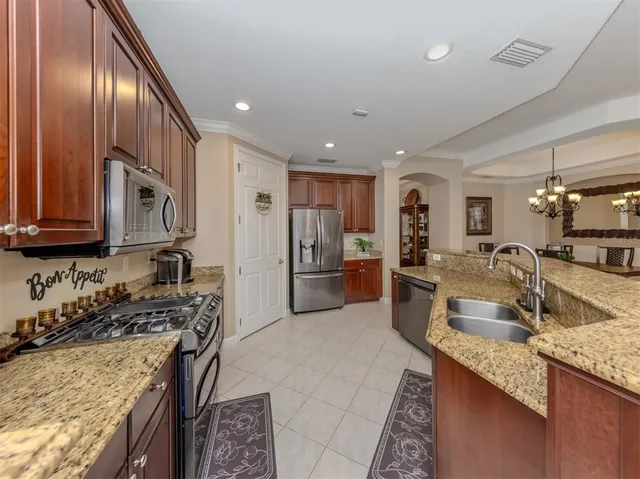 a bedroom with a bed a dresser and potted plants with the wooden floor