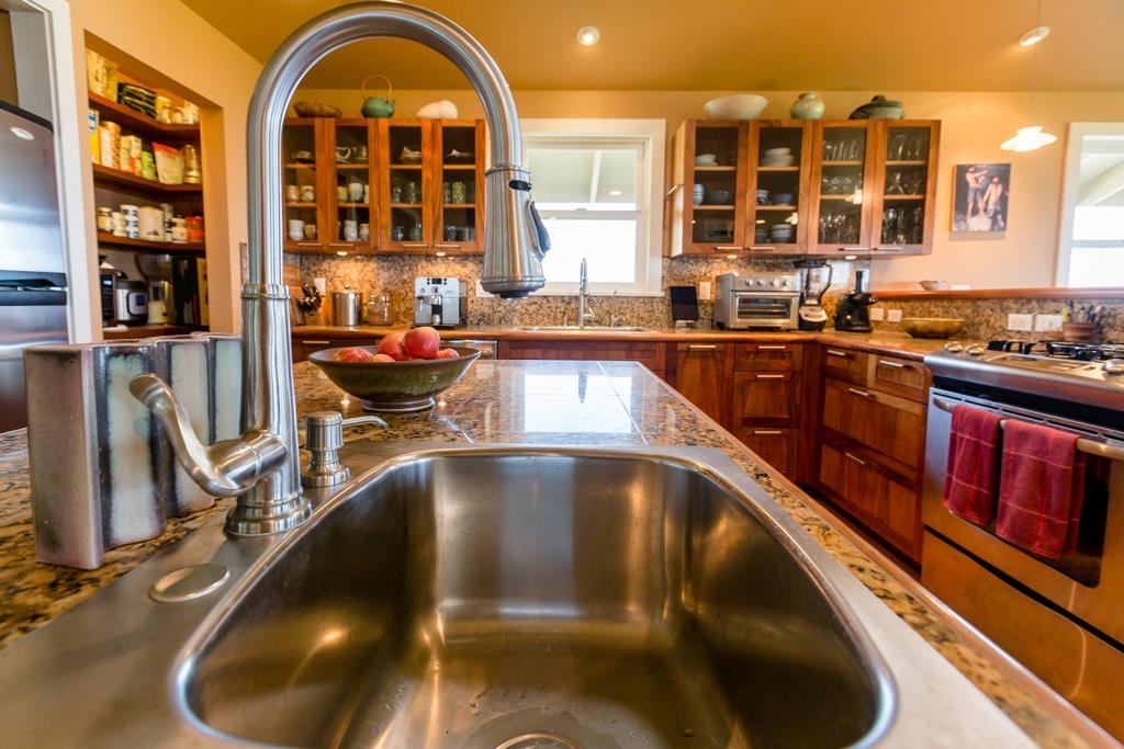 130 North Honokala Road Haiku, HI 96708 - Photo 15 of 30 a kitchen with stainless steel appliances granite countertop a stove and cabinets