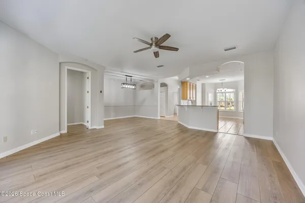 a view of an empty room with window and wooden floor
